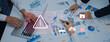 © InfiniteFlow - A business team collaborates around a table, analyzing data and charts while highlighting cybersecurity risks, emphasizing proactive management and secure strategies. Trope