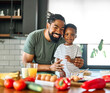 © Lumos sp - Portrait of a father and son preparing and eating breakfast and having fun in the kitchen at home