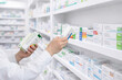 © Stanisic Vladimir - Pharmacist selecting medicine box from shelf in pharmacy, healthcare and retail drugstore concept