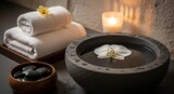 Serene Spa Setting with Rolled Towels Hot Stones and Floating Orchid.