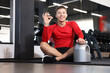 © New Africa - Happy young man with jar of protein powder showing ok gesture in gym