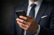 © Daria - Close up of businessman hand holding a smartphone in a formal suit, modern corporate communication concept for mobile business, finance apps, online services and executive productivity.