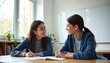 © Vadym - Teacher and student discuss learning goals at a desk in bright classroom. Woman helps girl with schoolwork, smiling and engaging in conversation about studies. Girl writes notes during lesson.