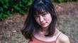 © swillklitch - Young woman with long wavy brown hair in strapless black top standing outdoors against soft tree background in warm autumn light