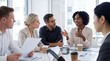 © Athena Studio - Diverse business professionals engaged in an active, focused discussion during a collaborative meeting in a modern.