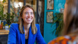 © Techno Stoks - A candid shot of a smiling professional woman in a blue jacket having a discussion in a creative workspace,