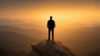 © buraratn - Silhouette of a Person Standing on a Rocky Outcrop Overlooking a Serene Mountain Landscape at Sunrise with Warm Golden Tones in the Sky