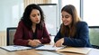 © ABUDARDA - Two businesswomen reviewing documents in a meeting