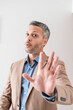 © Erik González - Mature businessman holding hand up in stop or wait gesture