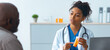 © Prostock-studio - A doctor talks to a patient about their prescription. The doctor holds a prescription bottle while explaining details. The setting is a medical office with simple decor.