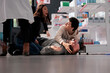 © DC Studio - People holding man with seizure symptoms, screaming for help in medical retail store. Drugstore client fainted near medication shelf and having epilepsy disorder attack on pharmacy floor
