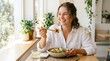 © Zainuddin - Woman eating healthy salad with chopsticks by the window in a bright room