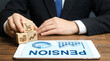 © Phamminn - Professional business person holding wooden block featuring financial icon looking at the word pension, representing retirement planning, investment growth, and future security strategy.