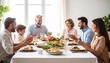 © Helois - Multi-generational family enjoying a festive holiday meal together around a dining table.