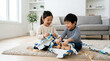 © D-stock photo - Happy asian little children playing with wooden toys in living room at home