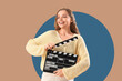 © Pixel-Shot - Beautiful actress with movie clapper on beige background