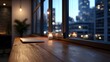 © Bussakon - A modern wooden desk setup featuring an open laptop and a candle set against a dramatic backdrop of illuminated city lights at night
