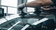 © Momoy Std - Mechanic holds suction cups on windshield; auto glass work in shop