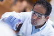 © .shock - Young laboratory doctor wearing goggles examines a blood sample in a medical testing lab