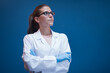 © .shock - Confident female doctor in lab coat and gloves looking up in clinical blood testing laboratory