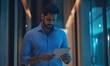 © Visual Odyssey - Man using tablet in modern office space with blue lighting and professional attire looking down