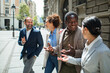 © Marko Geber - Diverse business colleagues chatting on city street