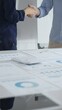 © rogerphoto - Professional businesspeople concluding deal, shaking hands near financial paperwork, calculator, pen on pristine workspace surface. Handshake concept