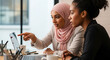© Arrhman - Diverse businesswomen collaborate on laptop discussing project in modern office.