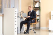 © Pixel-Shot - Young businessman working with laptop at desk in office