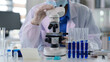 © STBSTD - Scientist adult professional laboratory worker operates microscope analyzes samples develops research performs experiment medical healthcare