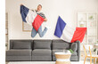 © Pixel-Shot - Happy young man with flags of France jumping at home