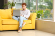 © Pixel-Shot - Male freelancer working with laptop on sofa at home