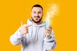 © Pixel-Shot - Young man pointing at nebulizer on yellow background