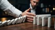 © Sukon - A hand stopping a domino effect to demonstrate business process control and prevention.