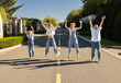 © Anna - happy, freedom-loving family: mother, father, children of different ages jumping together in the park in the sun. Positive thinking and dreams. Children and parents express joy, delight, and happiness