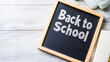 © Nitcharee - Wooden-framed chalkboard displays 'Back to School' on weathered wood