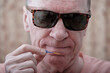 © Alex - A man examines a dental brush before using it.