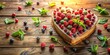 © VisualVault - Heart-shaped dessert adorned with assorted berries and fresh mint leaves, artfully arranged on a rustic wooden surface, bathed in warm, natural light.