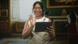 © Krakenimages.com - Woman in apron holding tablet and tapping screen while smiling in building; learning engagement serenity.