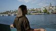 © Krakenimages.com - Woman with hands on railing overlooking waterfront and city buildings by a bridge and building promenade; nostalgia serenity.