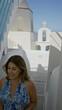 © Krakenimages.com - Woman walking up white steps holding sunglasses in a greek church building in santorini; serenity travel.