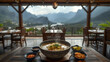 © rusdi - Steaming Bowl of Asian Noodle Soup with Scenic Mountain View Restaurant Background