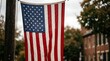 © VectorStar - American flag hanging on a pole with blurred background of trees and buildings  United States national symbol