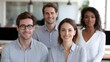 © Bussakon - A diverse professional group of colleagues smiling together in a bright modern office setting symbolizing teamwork and shared success