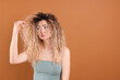 © New Africa - Unhappy woman with tangled damaged hair on brown background, space for text