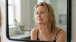 © Frame of the Dark - Beautiful mature woman looking in mirror for skin care routine, healthy senior face beauty concept