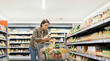 © Abul Kalam Azad - Woman shopping for groceries in a supermarket aisle