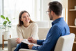 © Meow Creations - Smiling young woman sitting on a couch during a therapy session