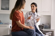 © fizkes - Professional Latina therapist holding modern digital tablet during conversation with woman patient, accessing electronic health record system, explain treatment plan or health test results. Healthcare
