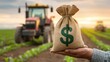 © 69 - Farmer Holding Open Money Bag in Field with Tractor at Sunset